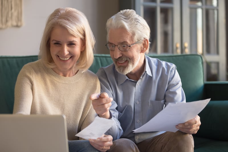 smiling seniors evaluating senior living financing